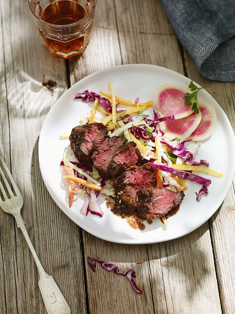 Beef steak and coleslaw on a wooden table