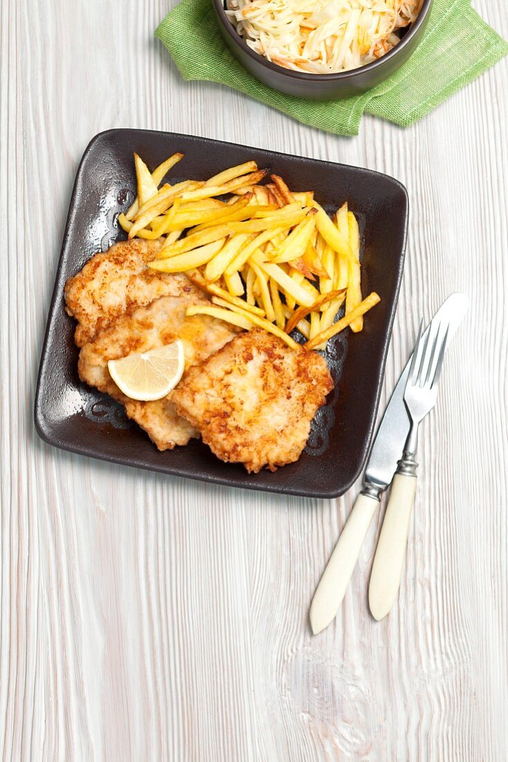 Schweinekoteletts mit Pommes Frites und Krautsalat