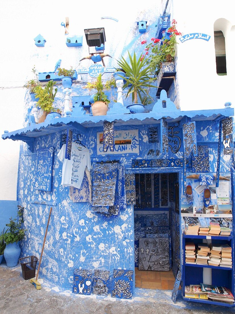 A blue-and-white artist's shop decorated with handprints in the Medina of Asilah, Morocco