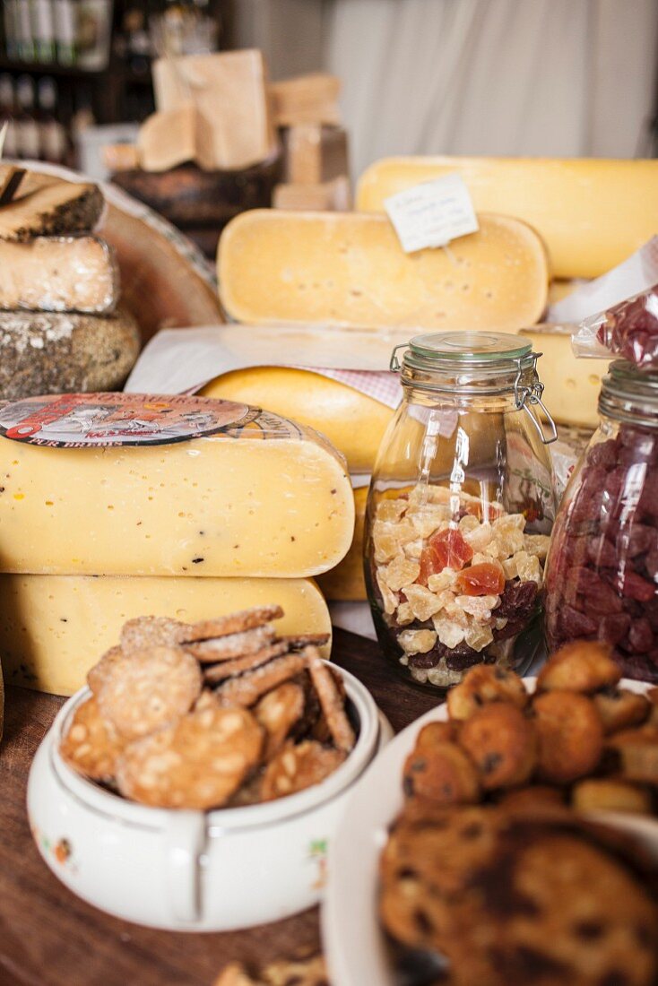 Various types of cheese, crackers and candied fruit in a delicatessen