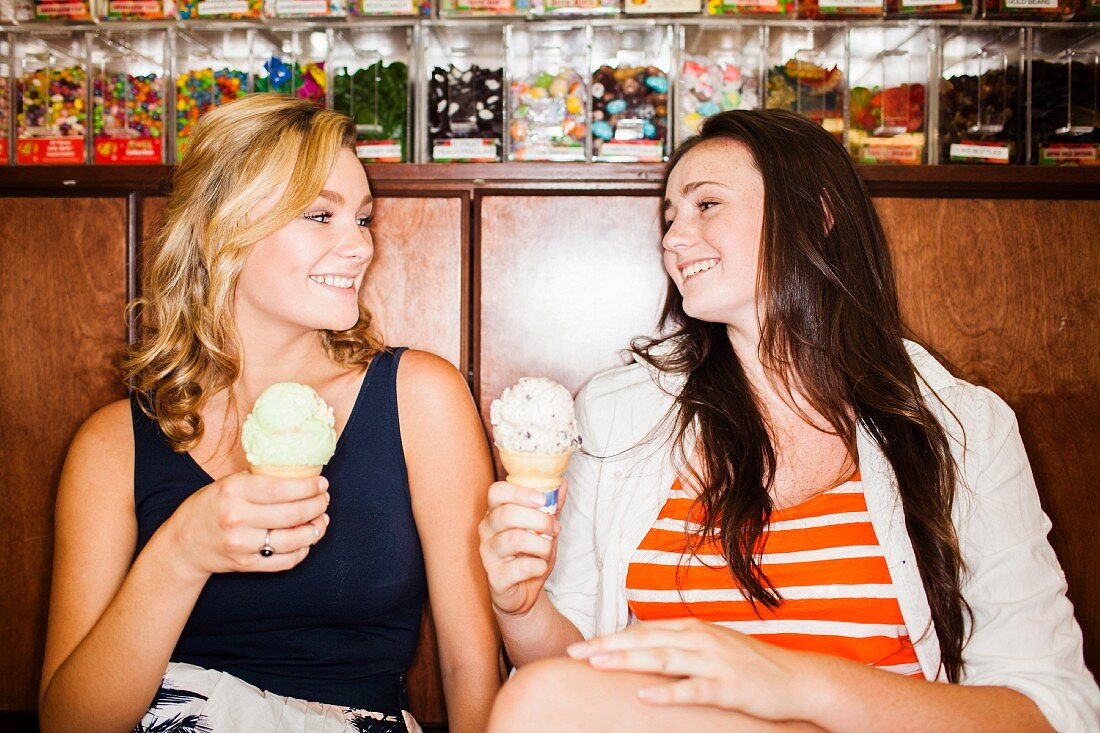 Zwei weibliche Teenager essen Eis im Café