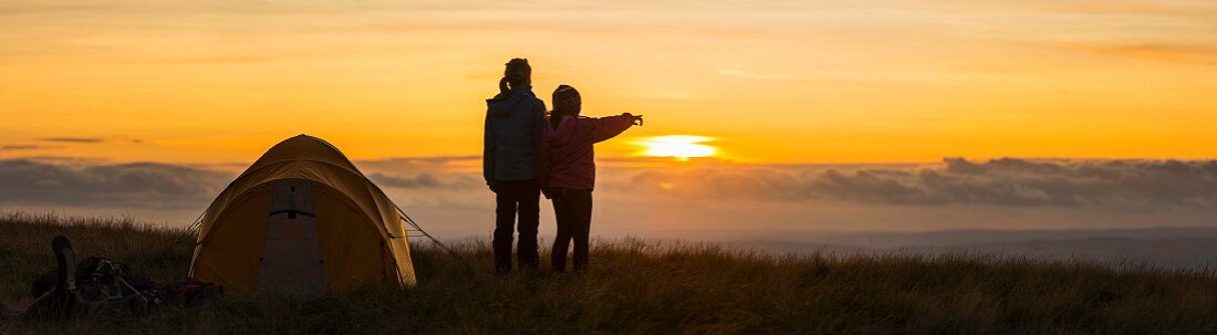 Silhouette von zwei Wanderern mit Blick auf den Sonnenuntergang