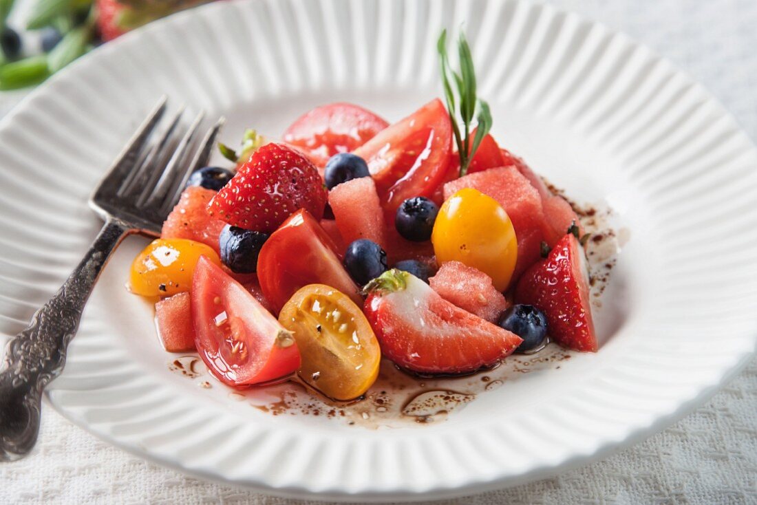 Roter und gelber Tomatensalat mit Wassermelonen, Erdbeeren, Heidelbeeren und Balsamico-Vinaigrette