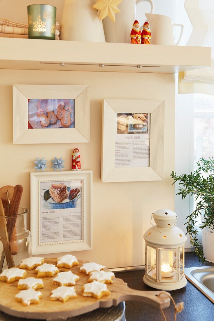 A Christmassy kitchen scene with cinnamon stars and favourite recipes framed on the wall