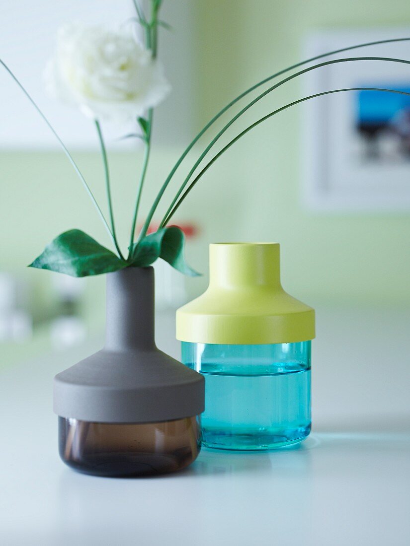 Blumenvasen aus farbigem Glas mit variablen Kunststoffaufsätzen