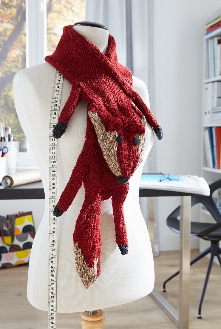 A tailor's dummy wearing a knitted, cashmere fox scarf