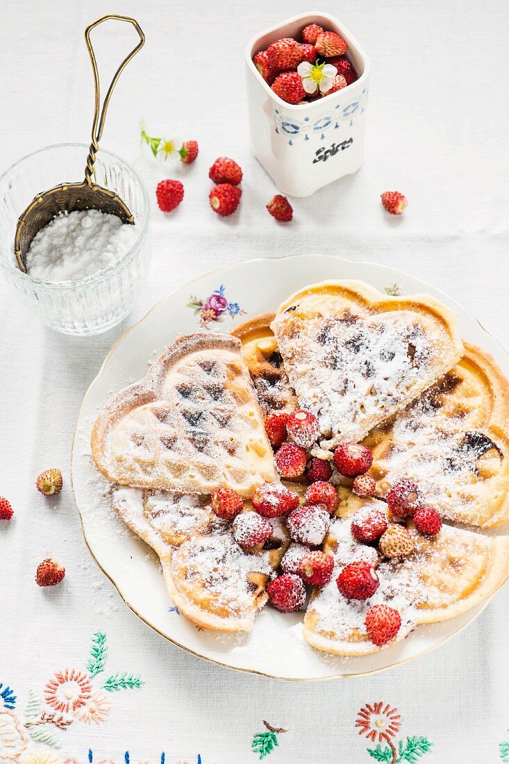 Waffles with icing sugar and wild strawberries