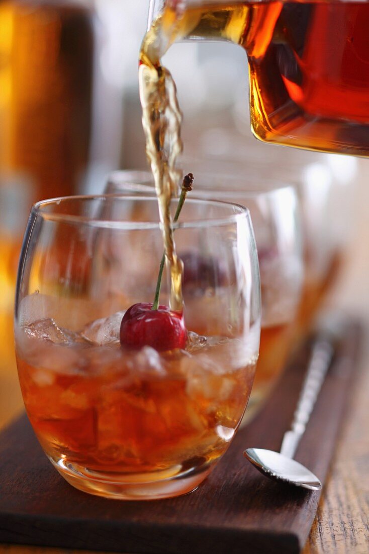 Whiskey with ice cubes and a cherry