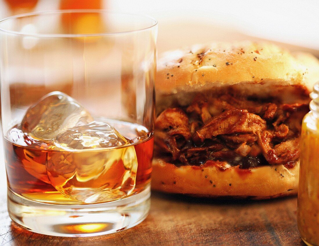 A pulled pork sandwich and a glass of rum