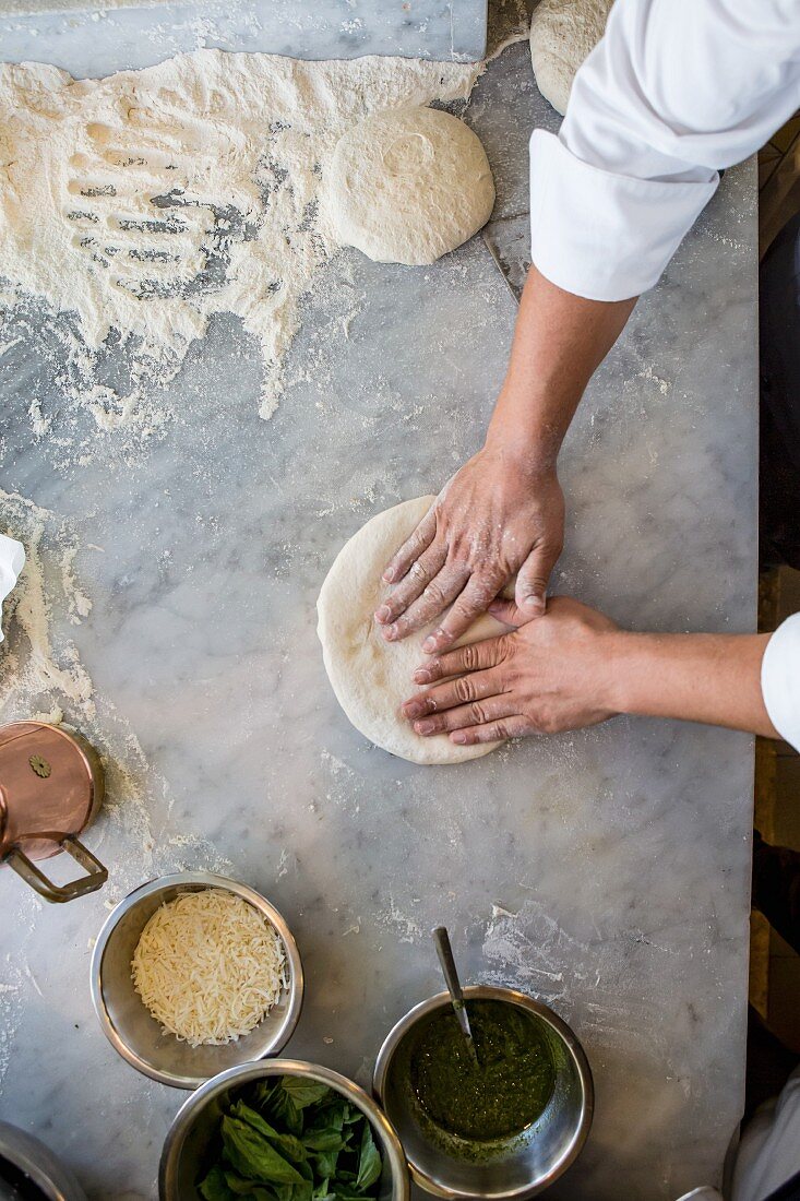 A pizza being made (dough being pressed flat)