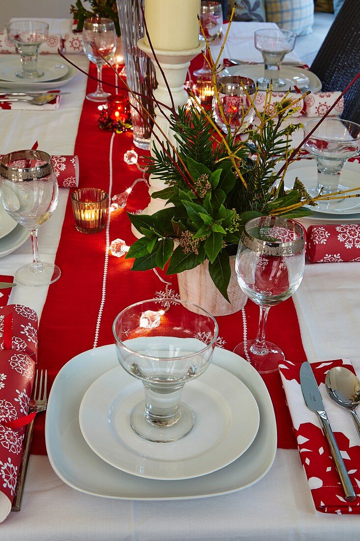 Table set for Christmas dinner with lit tealights in holders