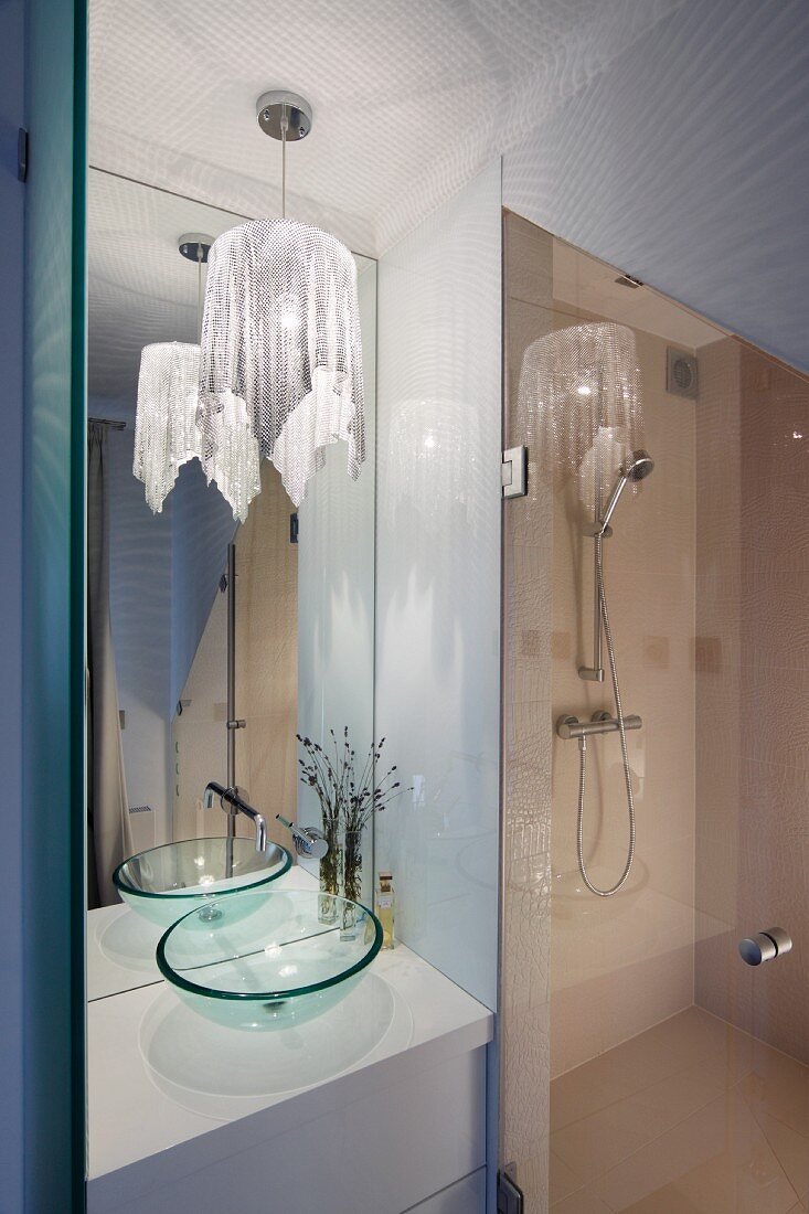 Elegant bathroom with shower, tall mirror and pendant lamp with glittery fabric lampshade