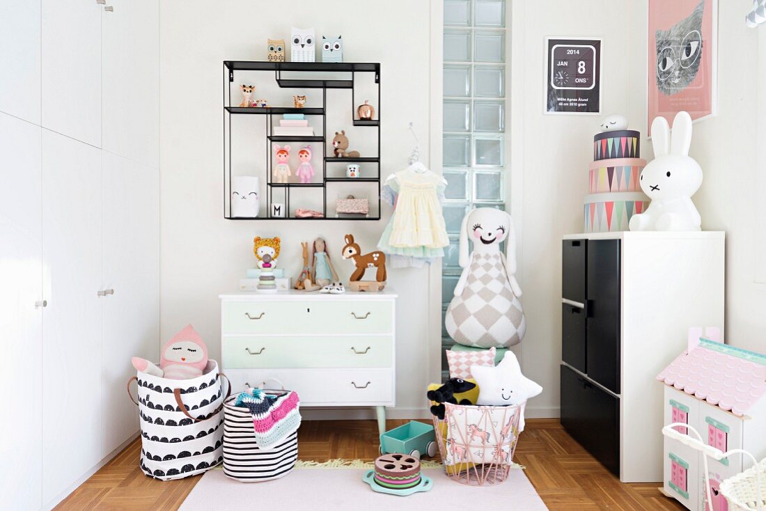 Toys in display case, storage bags on floor and decorative ornaments in nursery