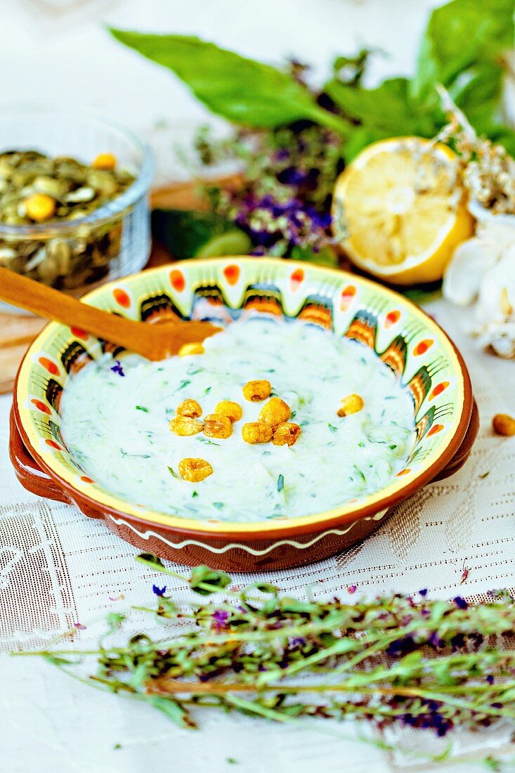 Traditional Bulgarian Tarator soup with herbs, lemons and salted corn
