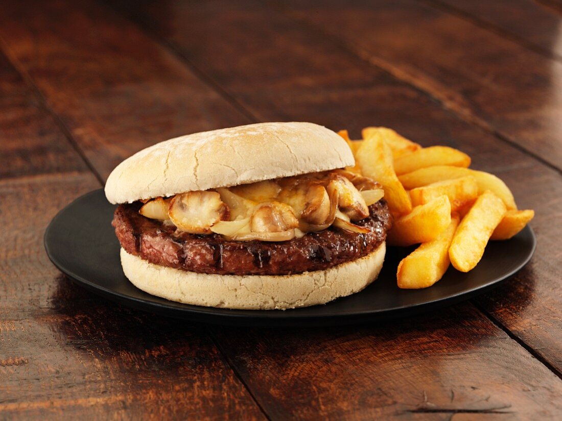 A beef burger with onions, mushrooms, cheese and chips