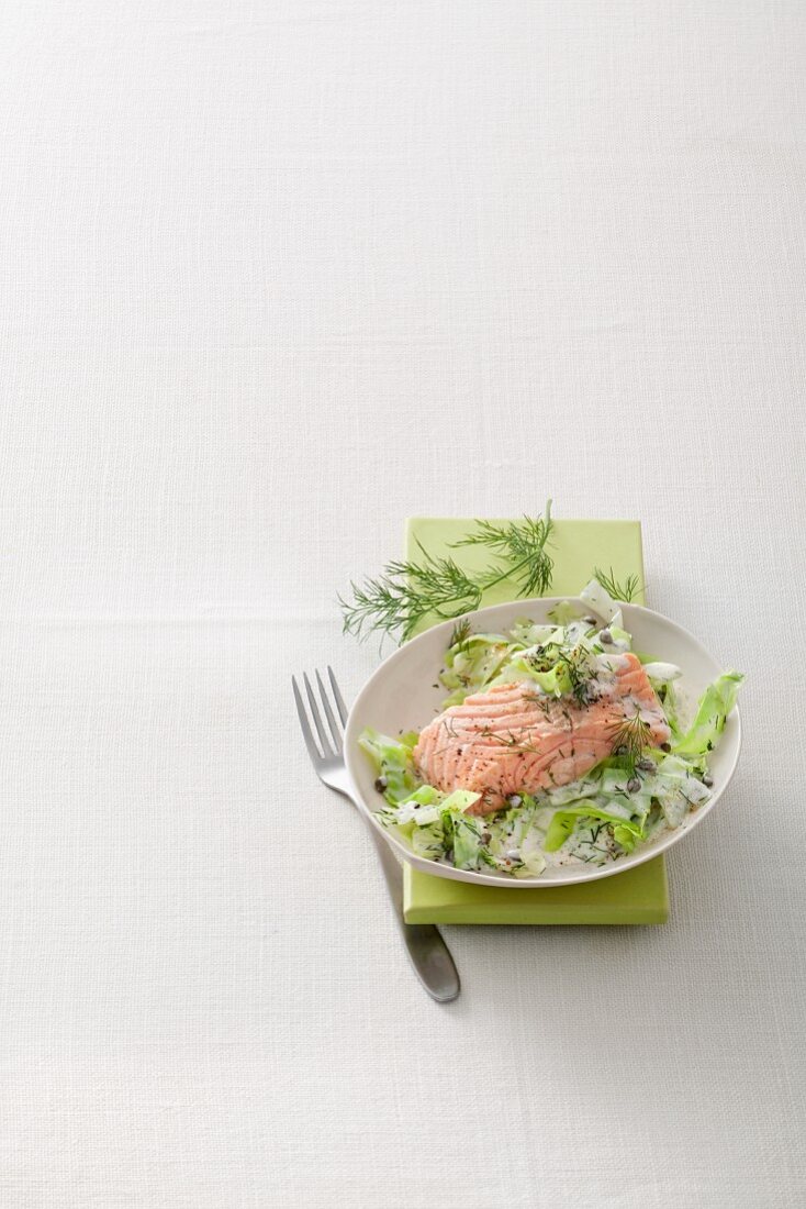 Salmon on a bed of pointed cabbage with a dill and soy sauce