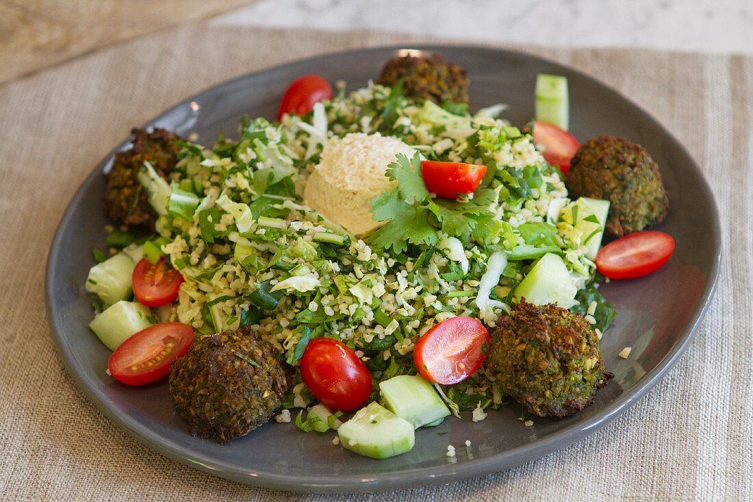 Bulgur salad with falafel, hummus, dandelion, kale, Chinese cabbage, cucumbers, tomatoes and mint