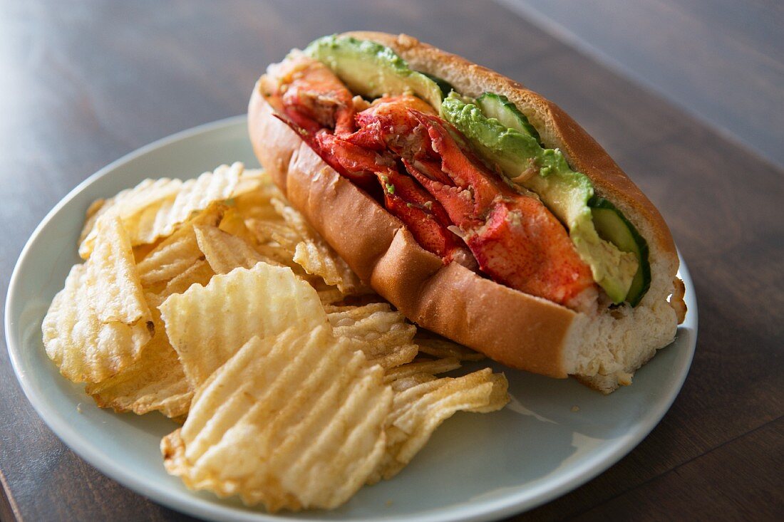 Grilled lobster rolls with avocado and pickles served with ridged potato crisps
