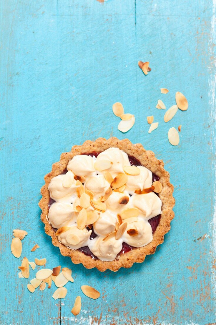 A tartlet with jam, meringue and flaked almonds