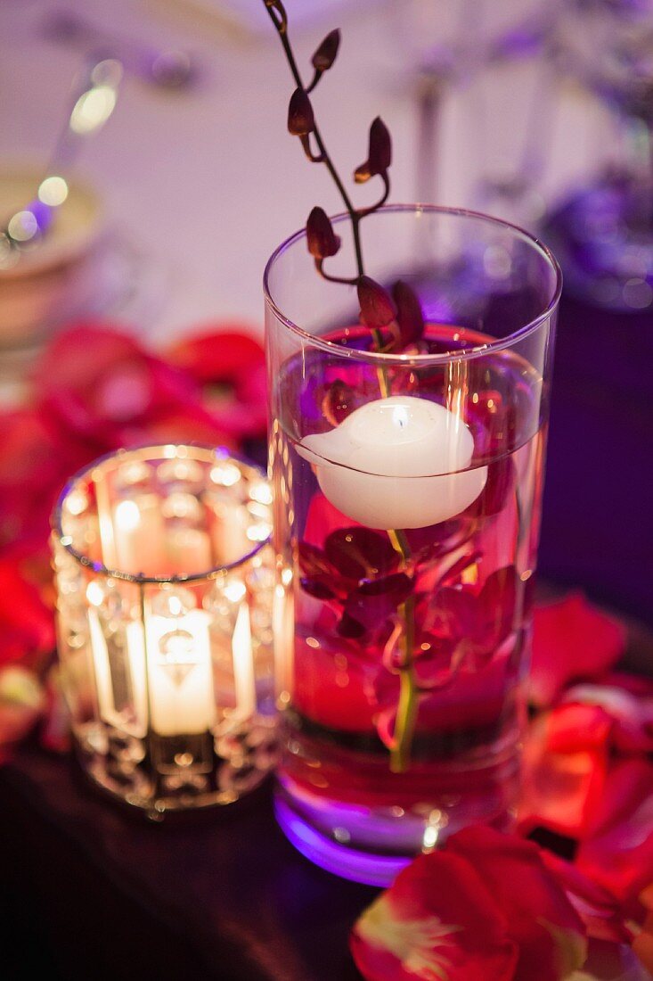 Detail of wedding table with floating candle and orchid in glass of water