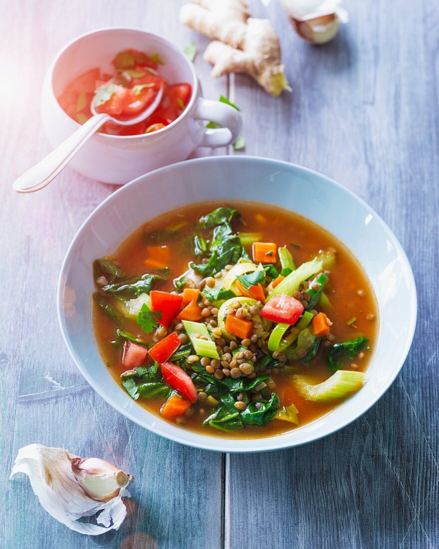 Spinach and lentil soup with leek, tomatoes and carrots