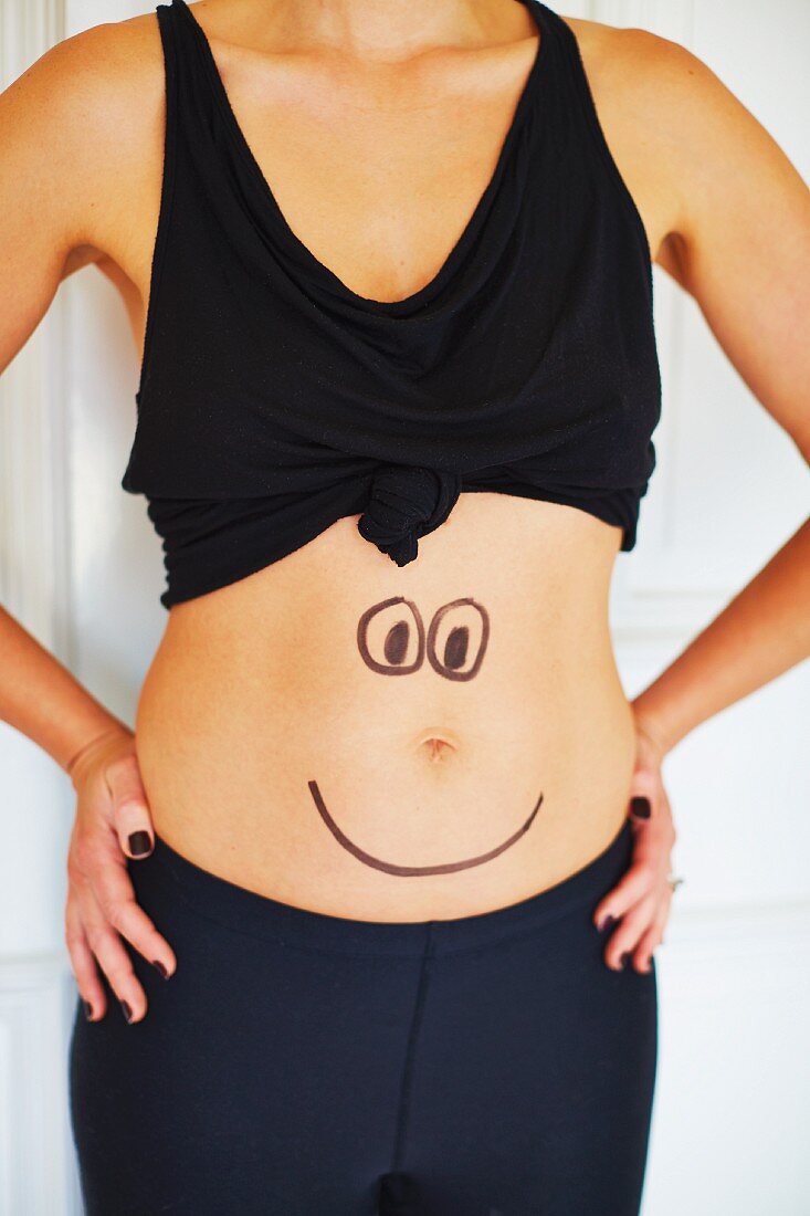 A woman with a face drawn on her tummy