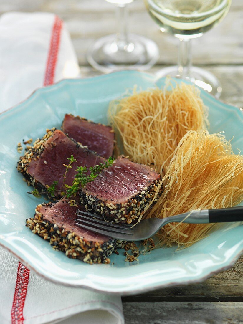 Tuna fish with sesame and poppy seeds served with fried rice vermicelli