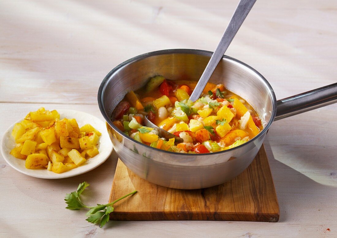 Bean soup with colourful vegetables and crispy potatoes