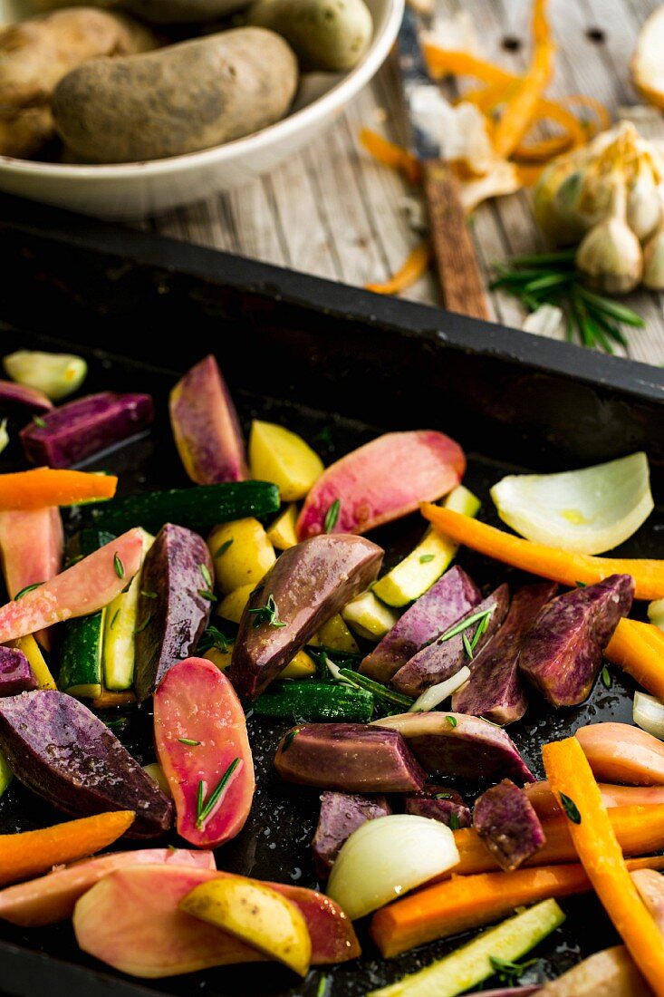 Gemüse mit Olivenöl, Rosmarin, Bohnenkraut und Fleur de Sel auf dem Backblech
