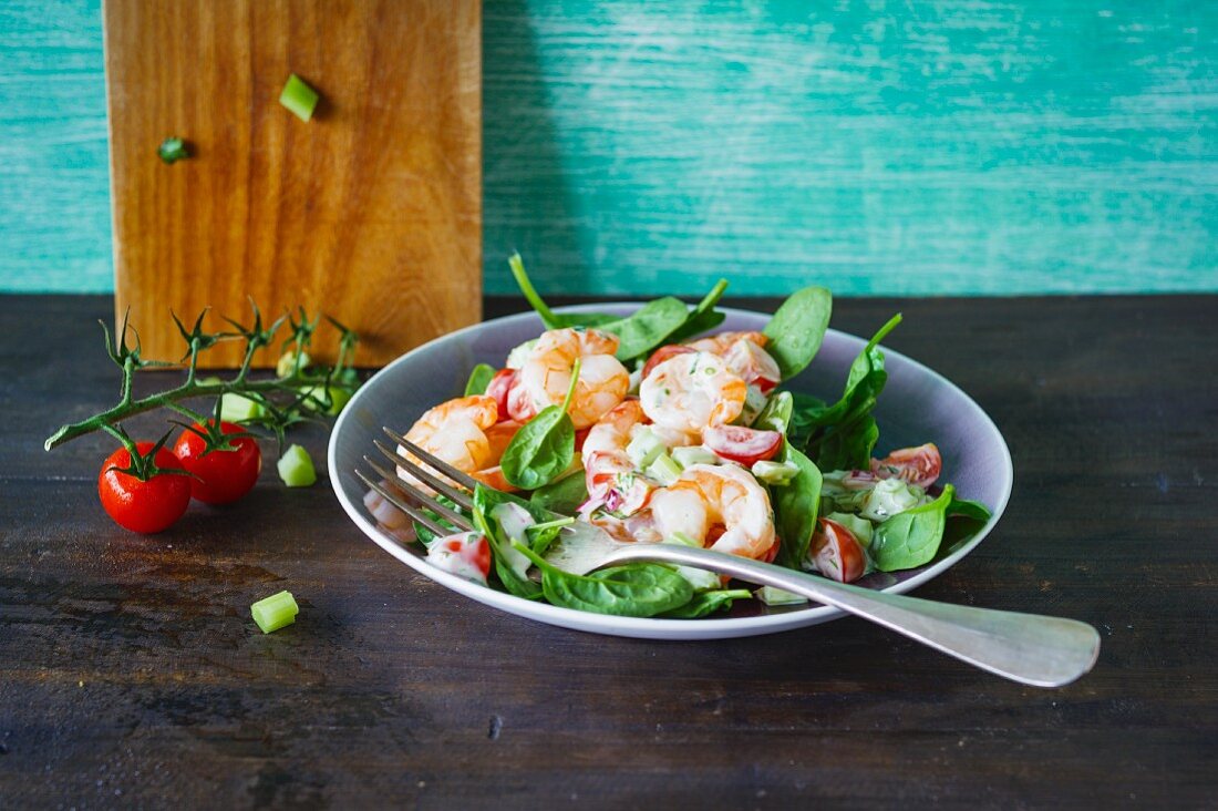 Salat aus frischem Blattspinat mit Shrimps, Kirschtomaten und Staudensellerie