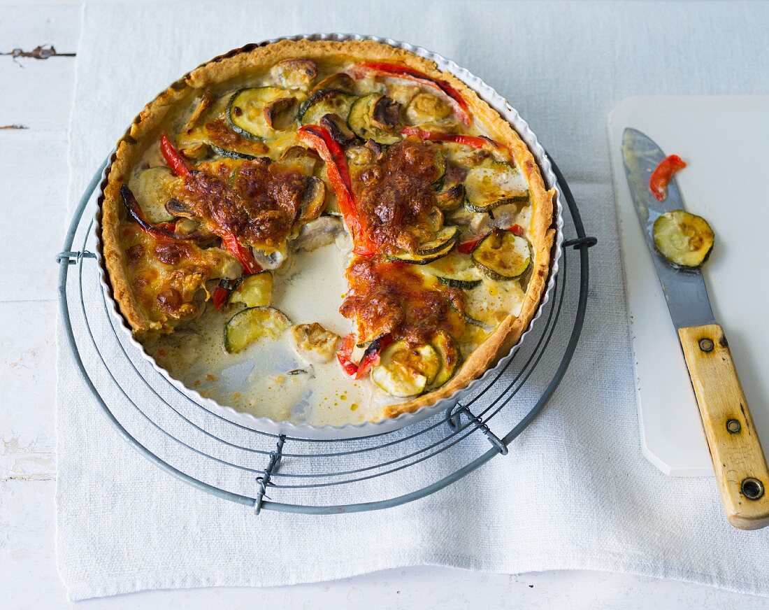 A colourful vegetable quiche with red peppers, courgettes and mushrooms