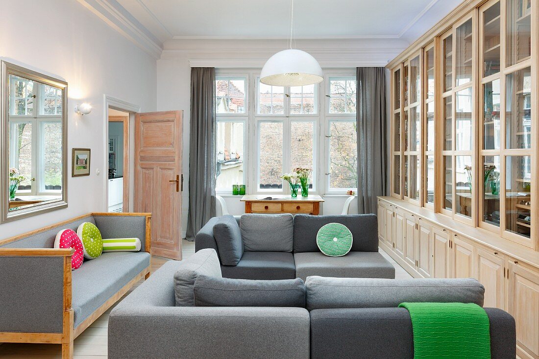 Elegant library with grey sofas in pleasant period apartment