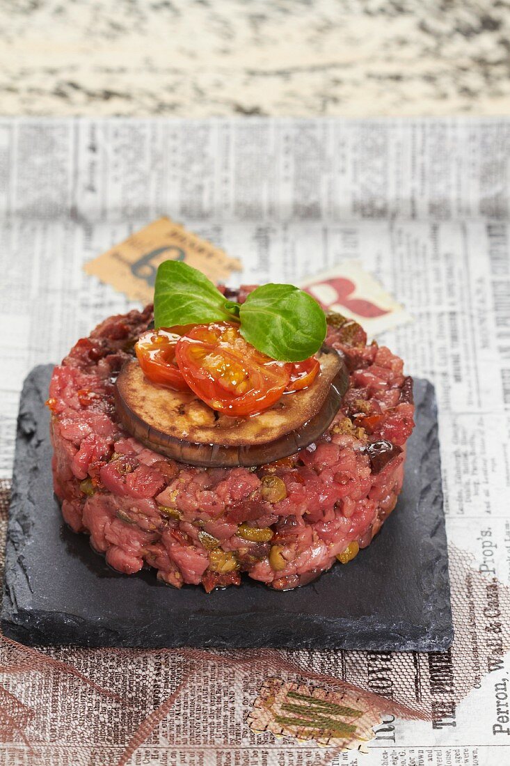 Beef tartar with capers, olives, dried tomatoes, basil, peppers and aubergines