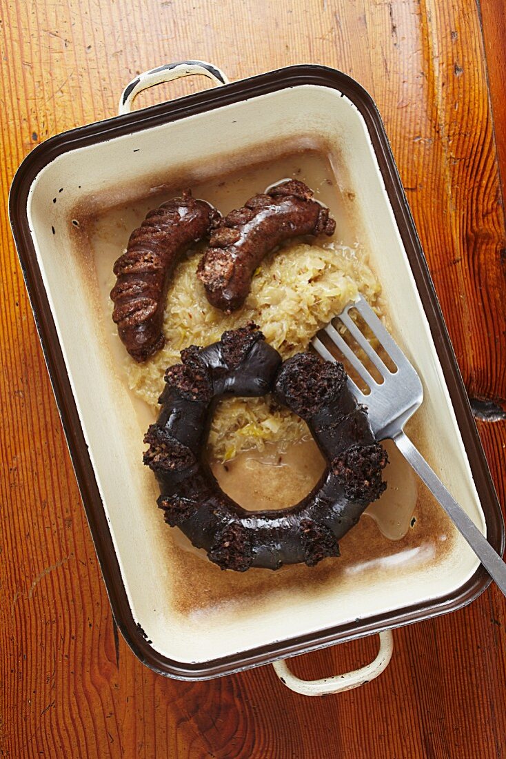 Black pudding, liver sausages and sauerkraut in a baking dish
