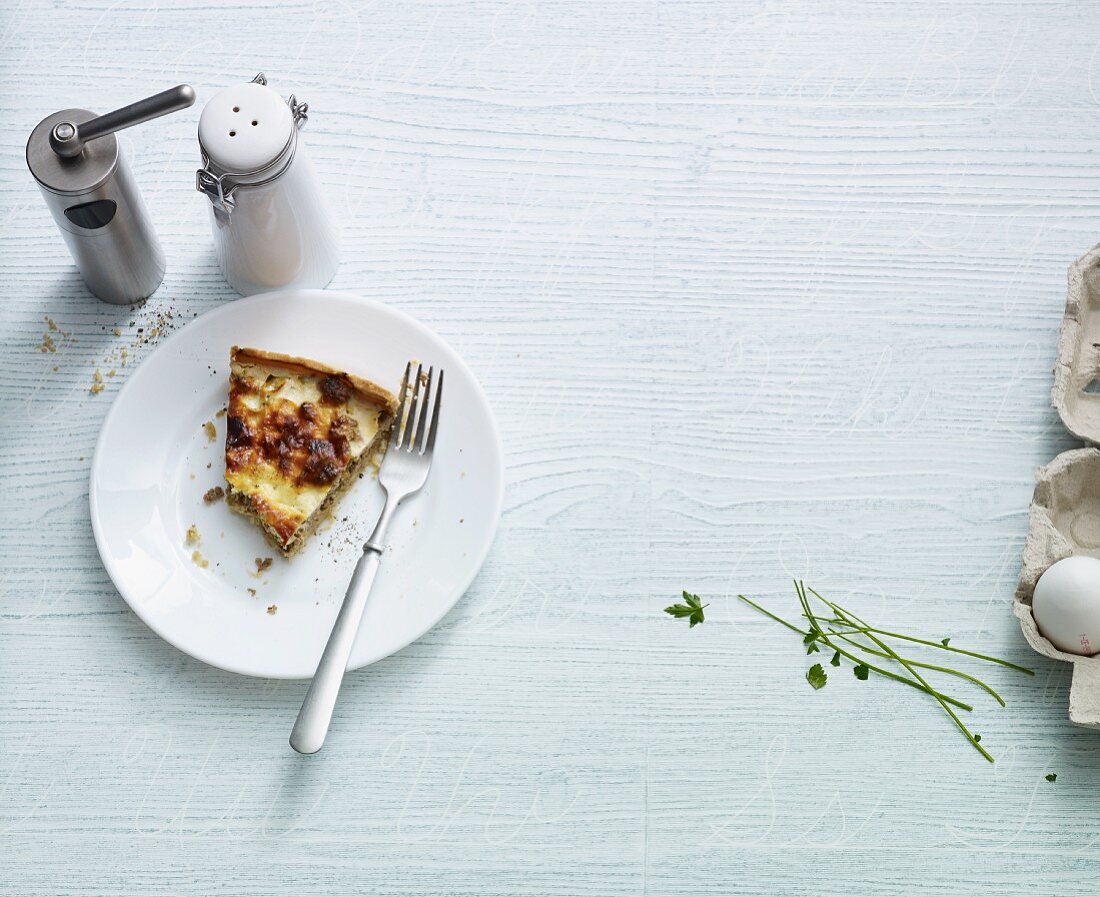 A slice of minced meat quiche with a bite taken out