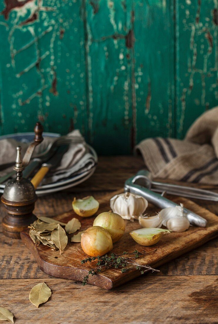 Onions, garlic and herbs on a chopping board