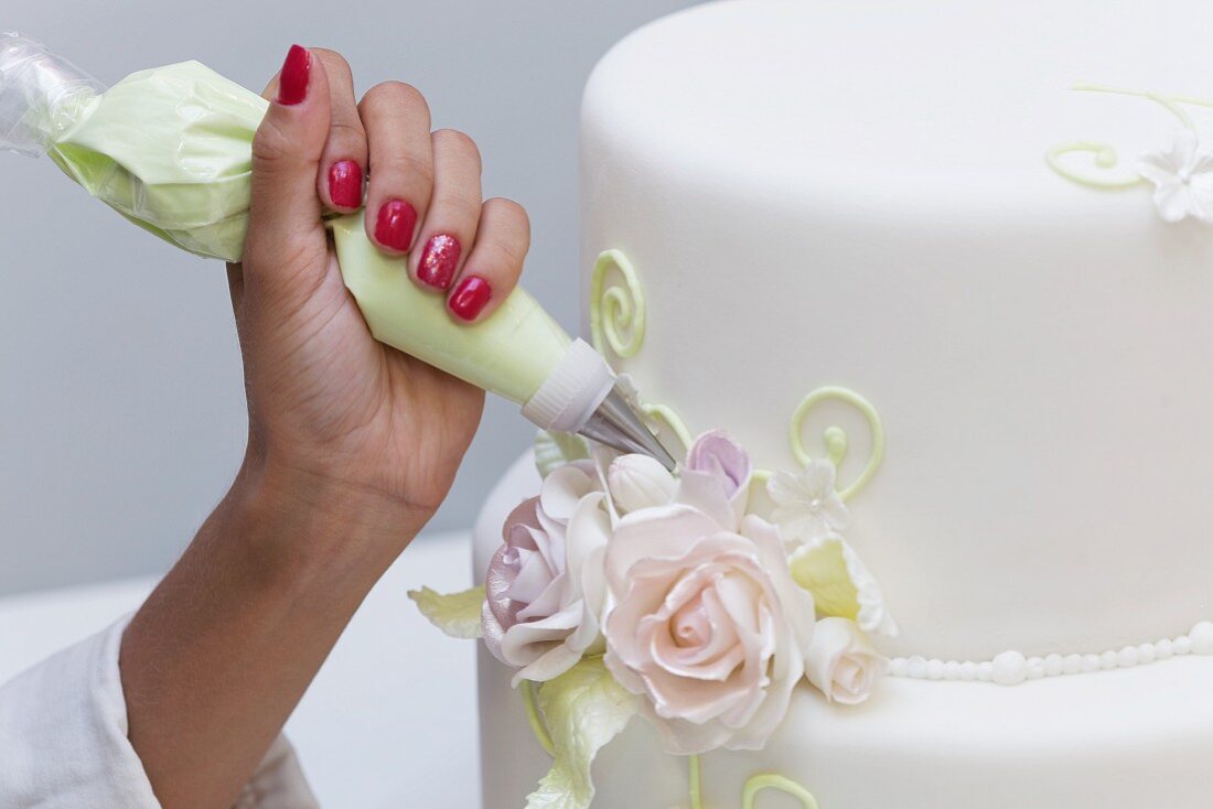 A wedding cake being decorated
