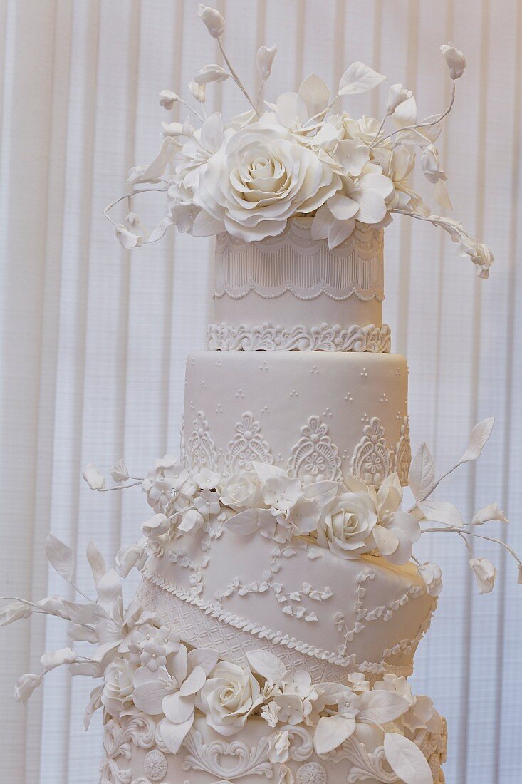 An artistically decorated wedding cake with elaborate flower decorations