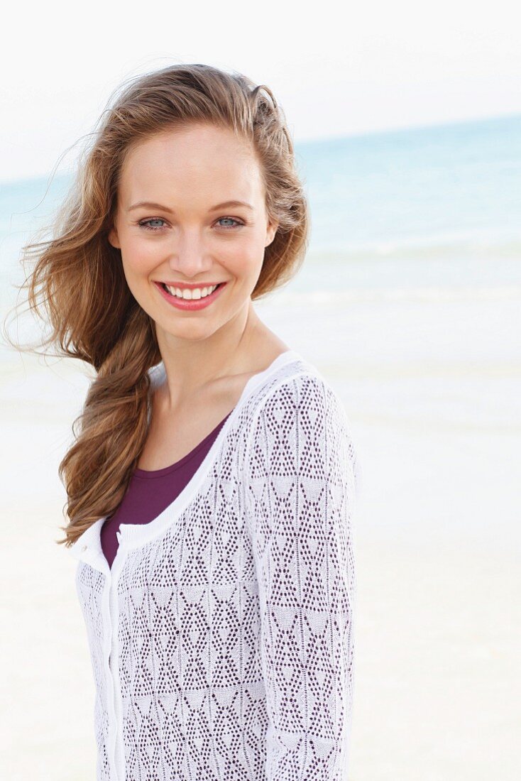 A young woman wearing a white lace jacket over a purple dress