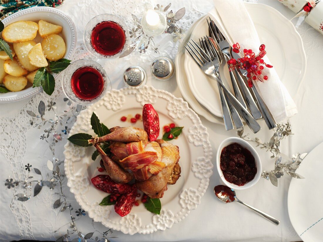 Roast pheasant wrapped in bacon with pomegranate seeds and potatoes for Christmas