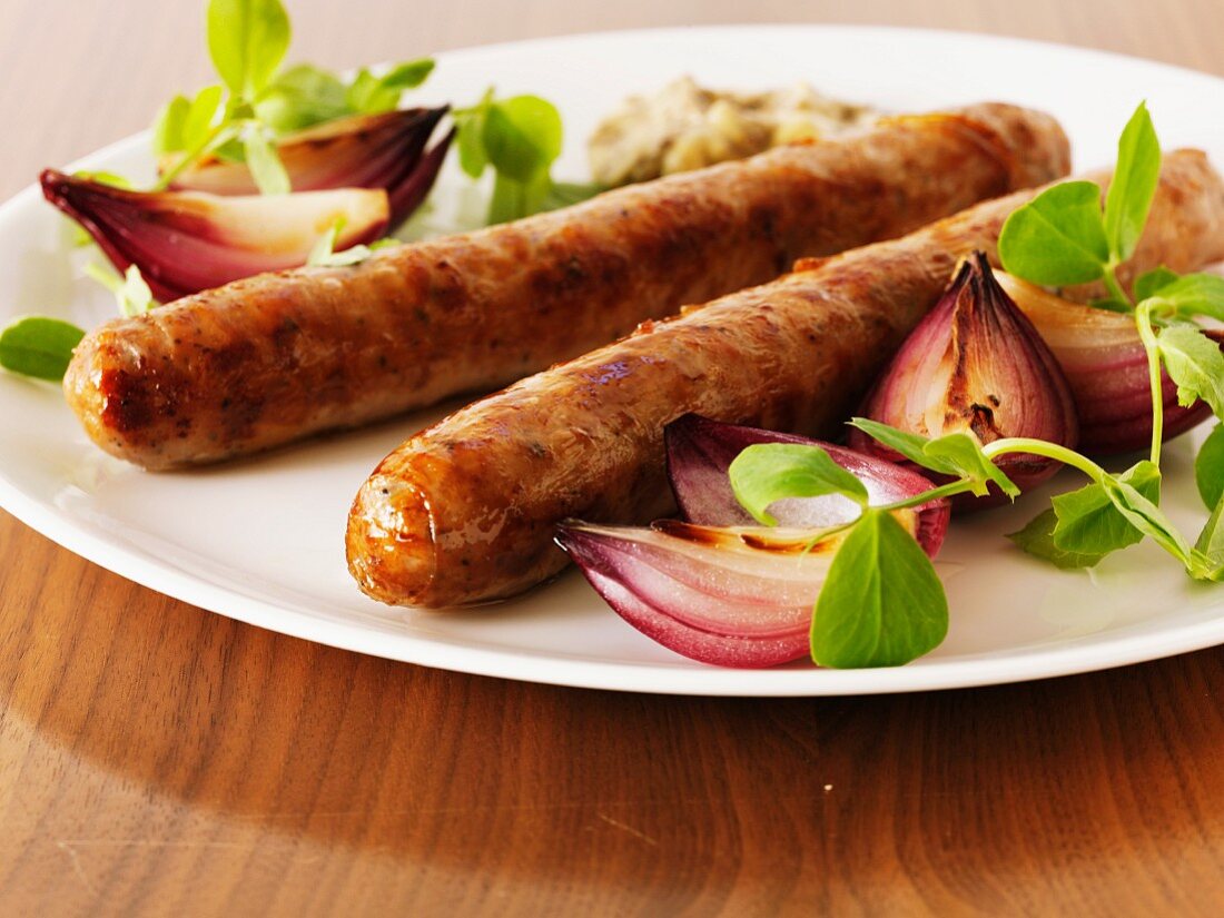 Sausages with red onions and pea shoots