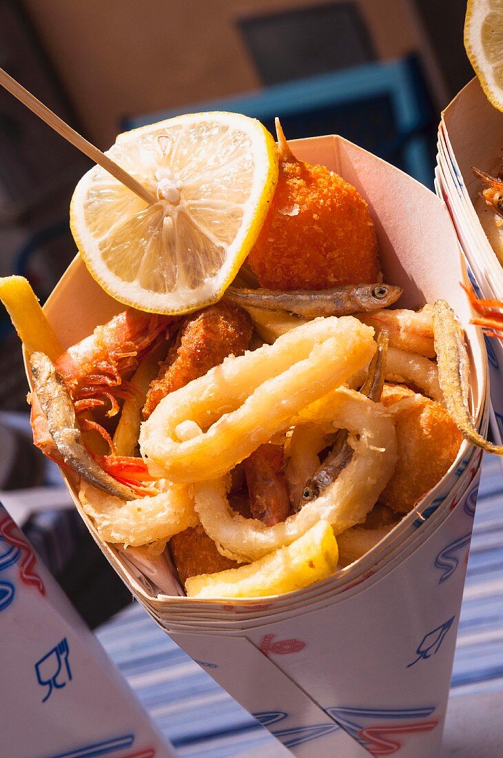 Fried fish and seafood with chips in a paper cone