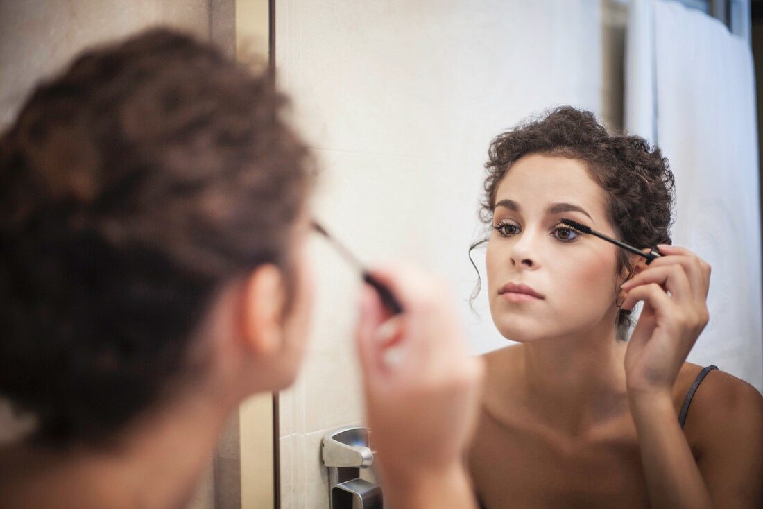 A young woman applying make-up