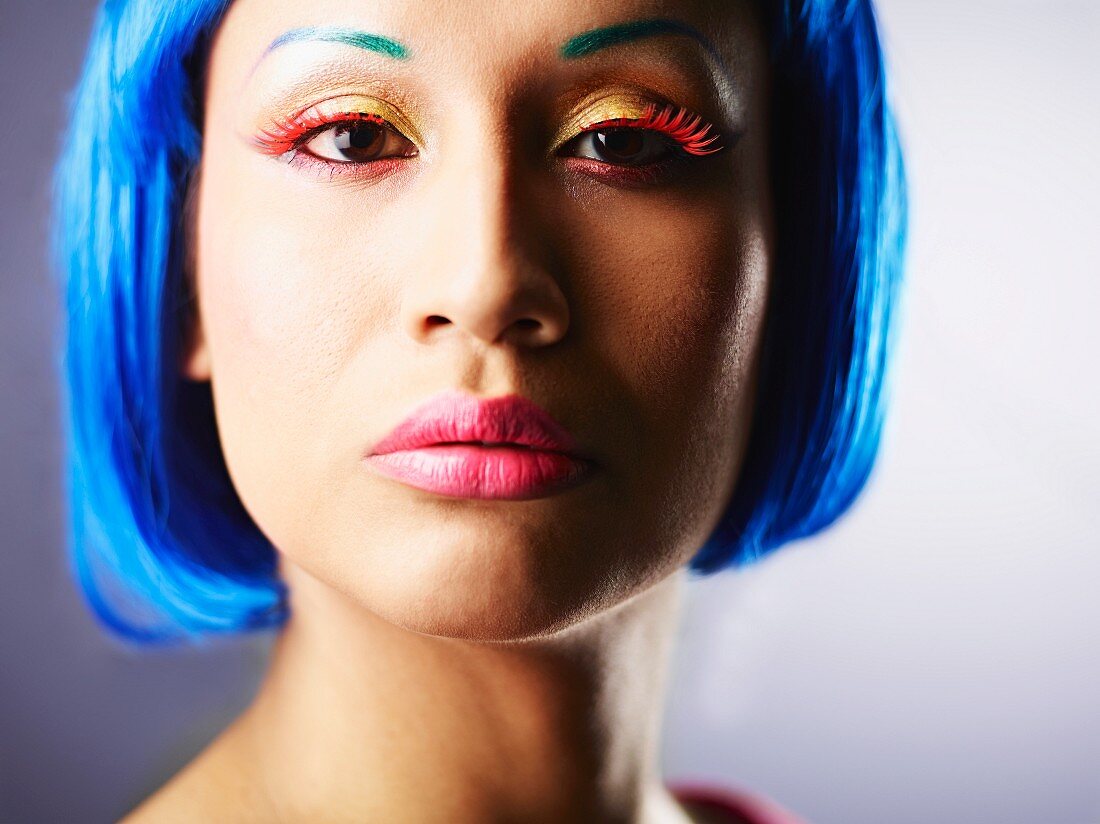 A woman with blue hair wearing bright make-up