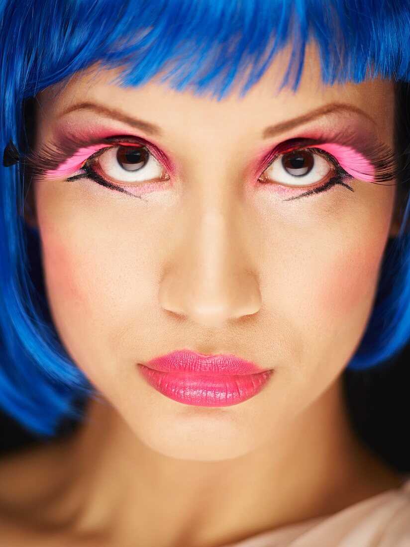 A young woman with blue hair and pink artificial eyelashes