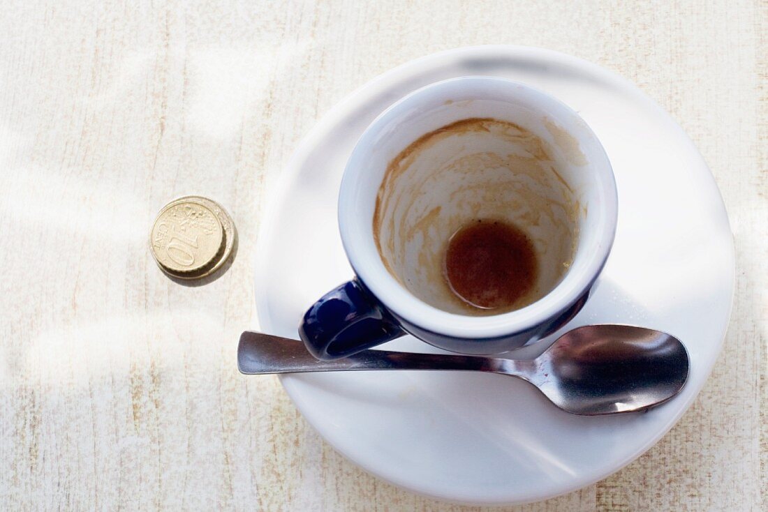 An empty espresso cup on a cafe table