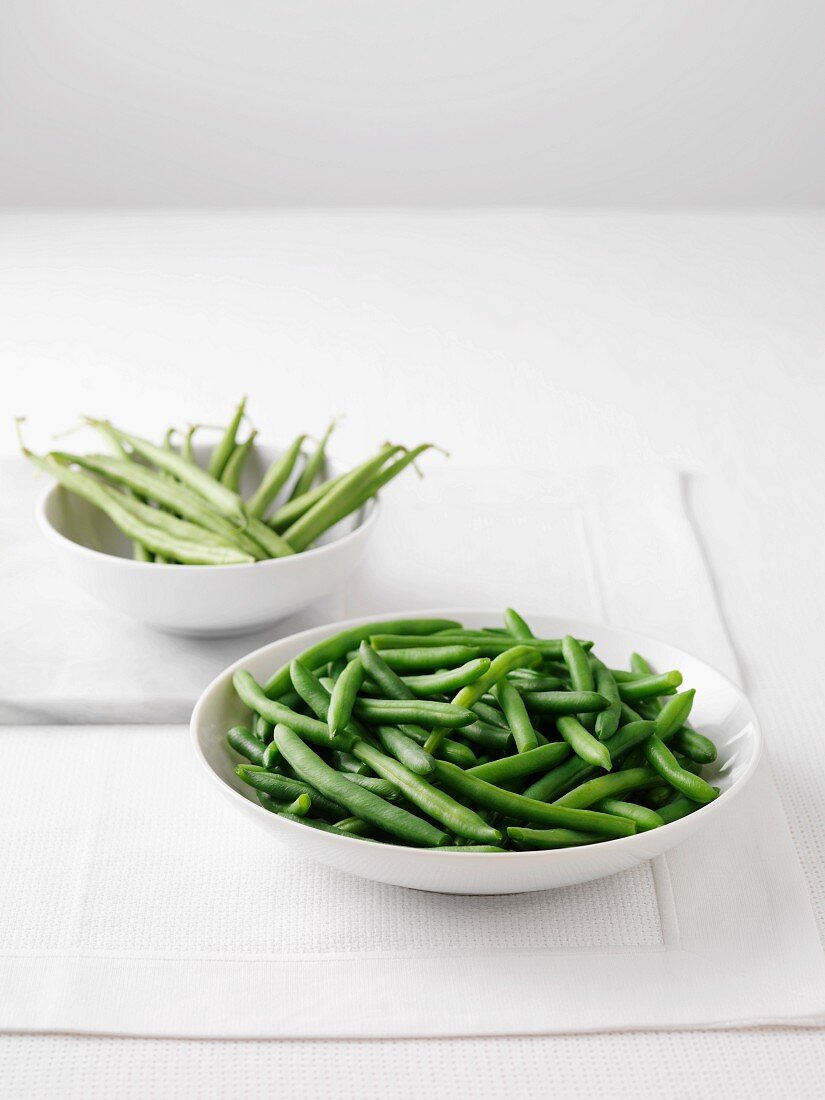 Fresh green beans and a bowl of boiled green beans