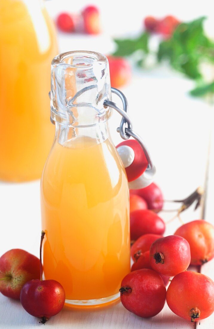 Fresh apple juice in a flip-top bottle decorated with ornamental apples