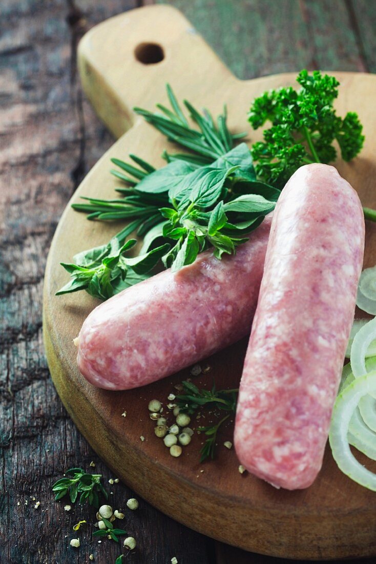 Raw sausage with herbs on a rustic wooden table