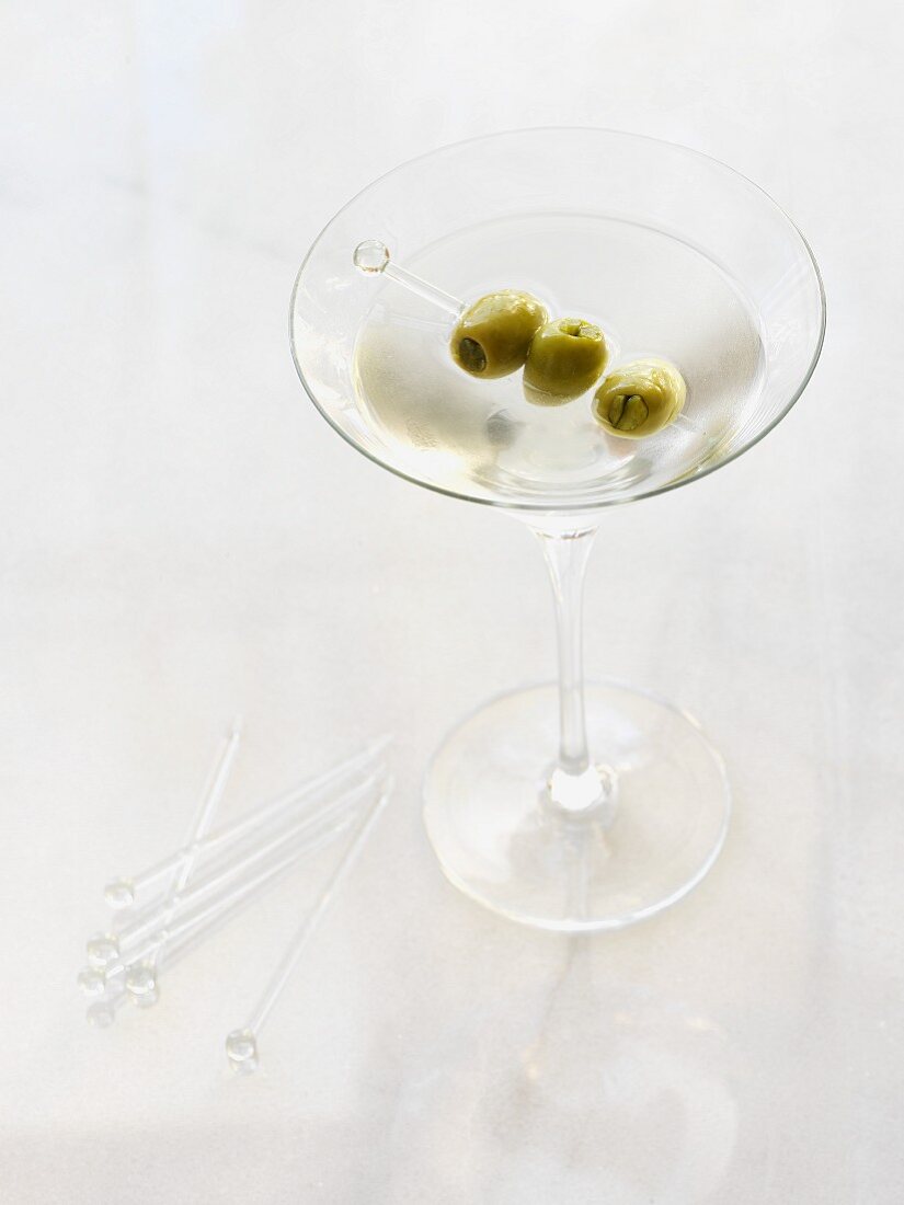 A dry Martini with an olive skewer
